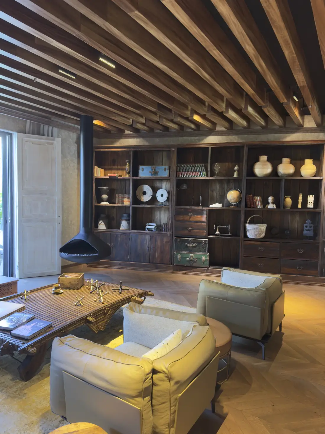 Salón de hotel boutique con vigas de madera y luz dorada lateral